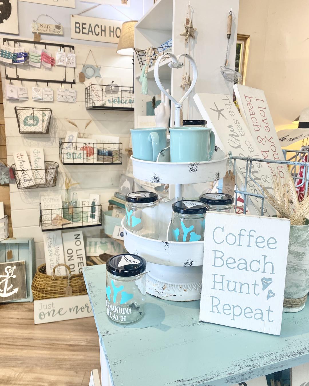coastal home decor display with handmade in usa coastal signs by anchored soul designs arranged on a shelf