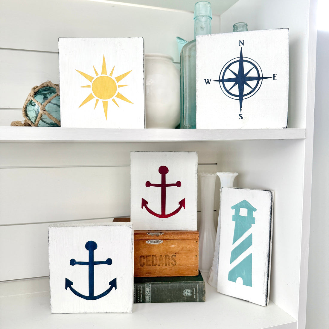 coastal home decor display with handmade in usa coastal signs by anchored soul designs arranged on a shelf