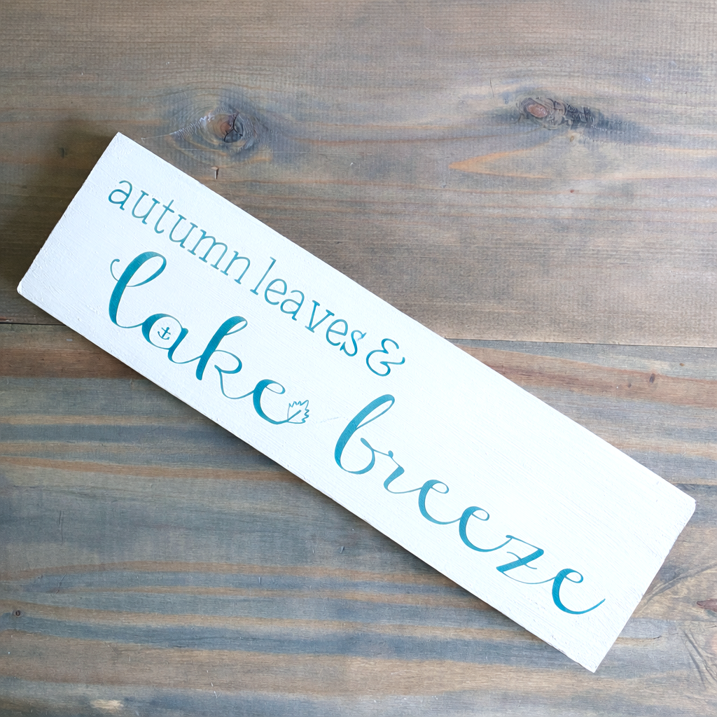 Wooden sign with 'autumn leaves & lake breeze' text on a wooden surface
