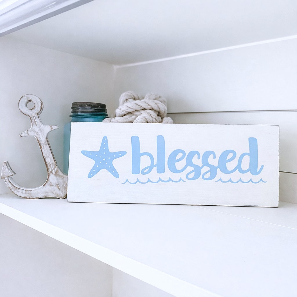Decorative sign with 'blessed' text on a shelf with decorative items.