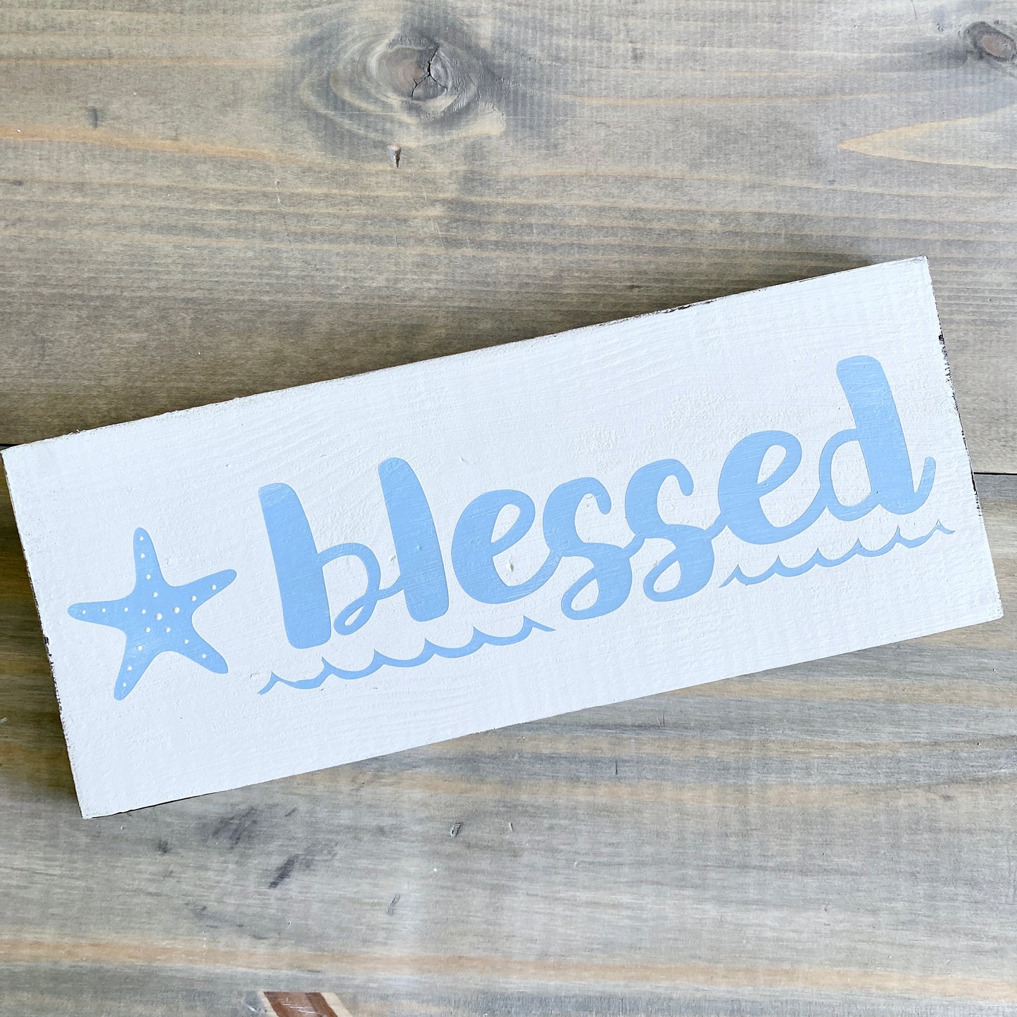 Decal with 'blessed' text and starfish design on a wooden surface