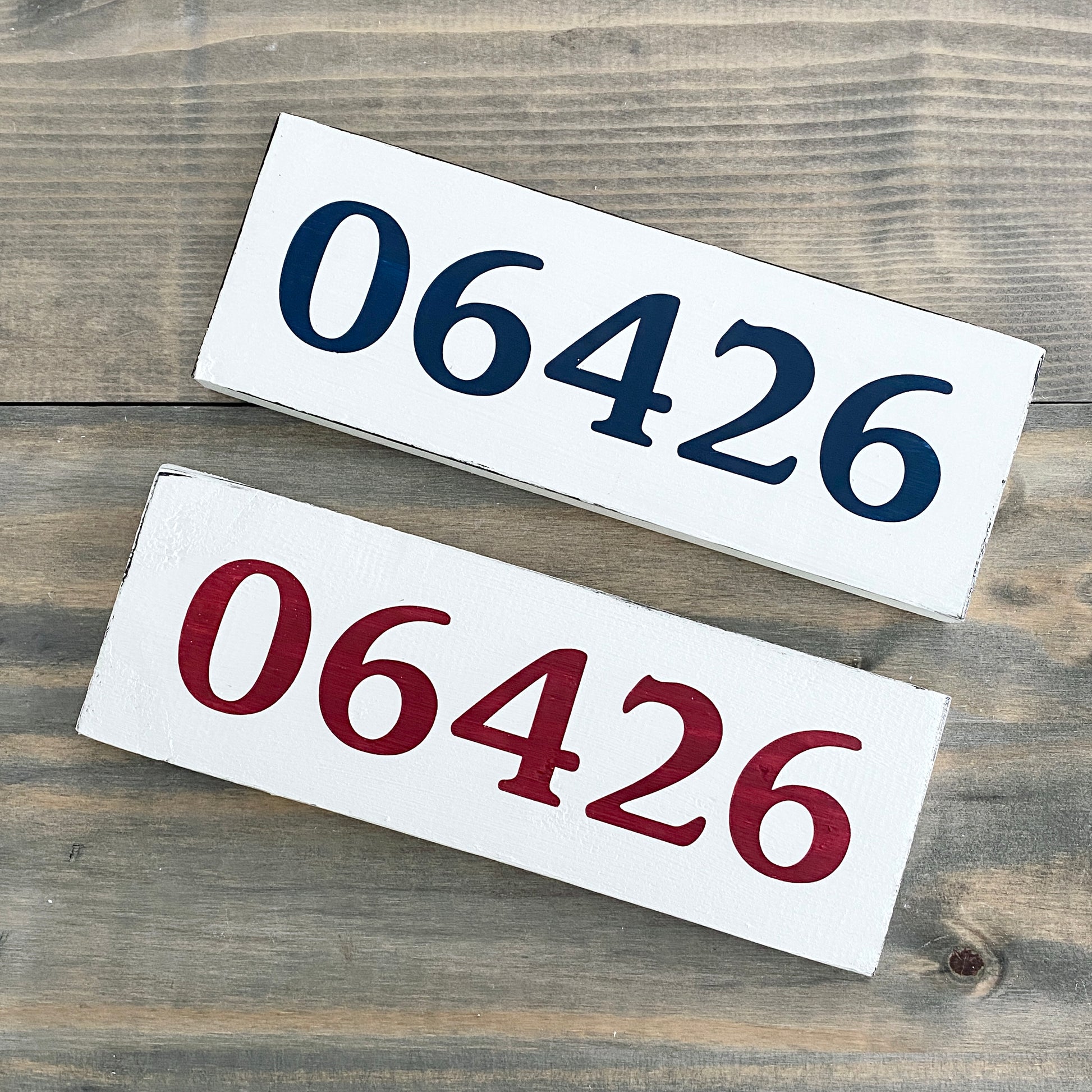 Two rectangular signs with the number '06426' on a wooden surface.