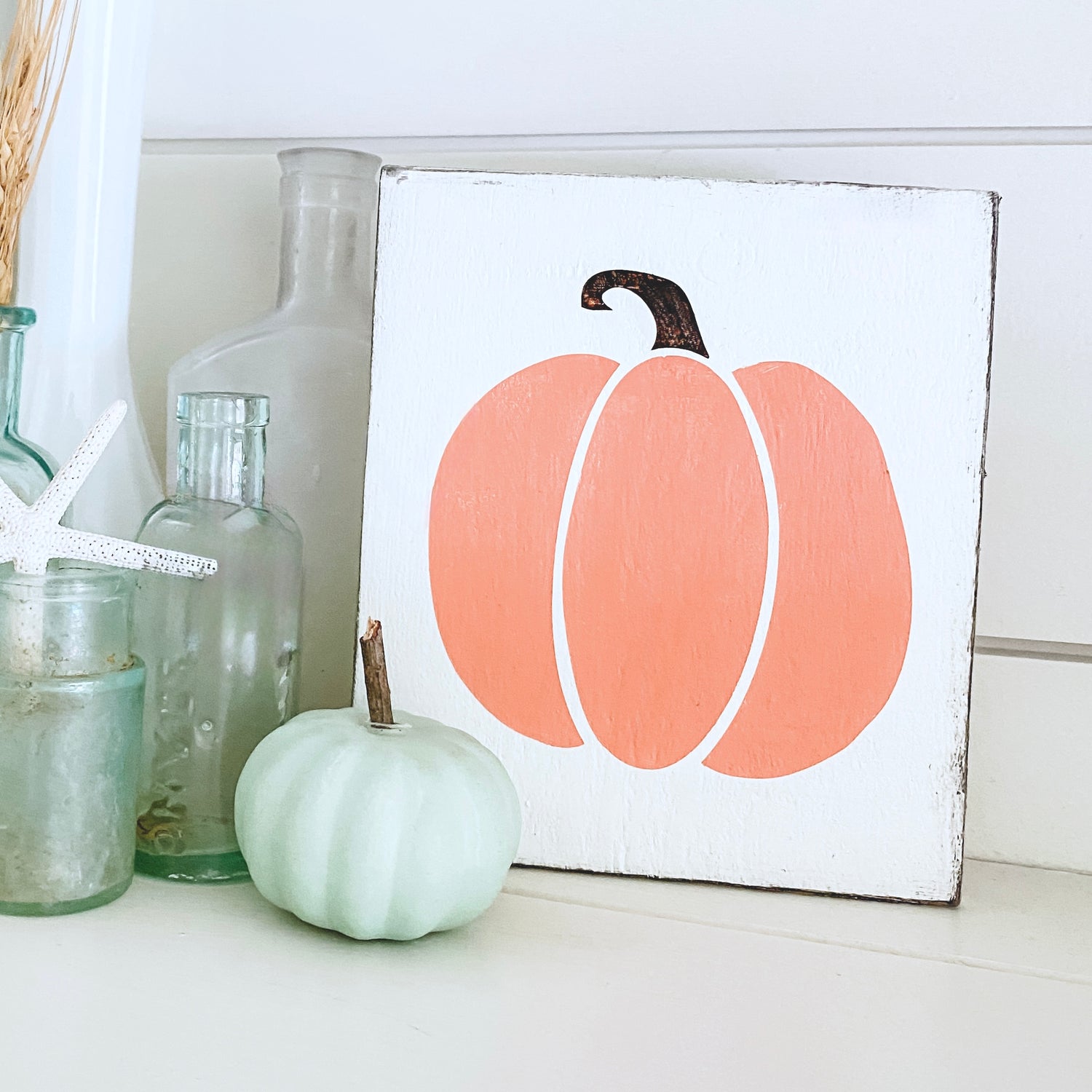 Modern Cottage Farmhouse Sign in pale orange sitting on a shelf with fall decor and vintage bottles 