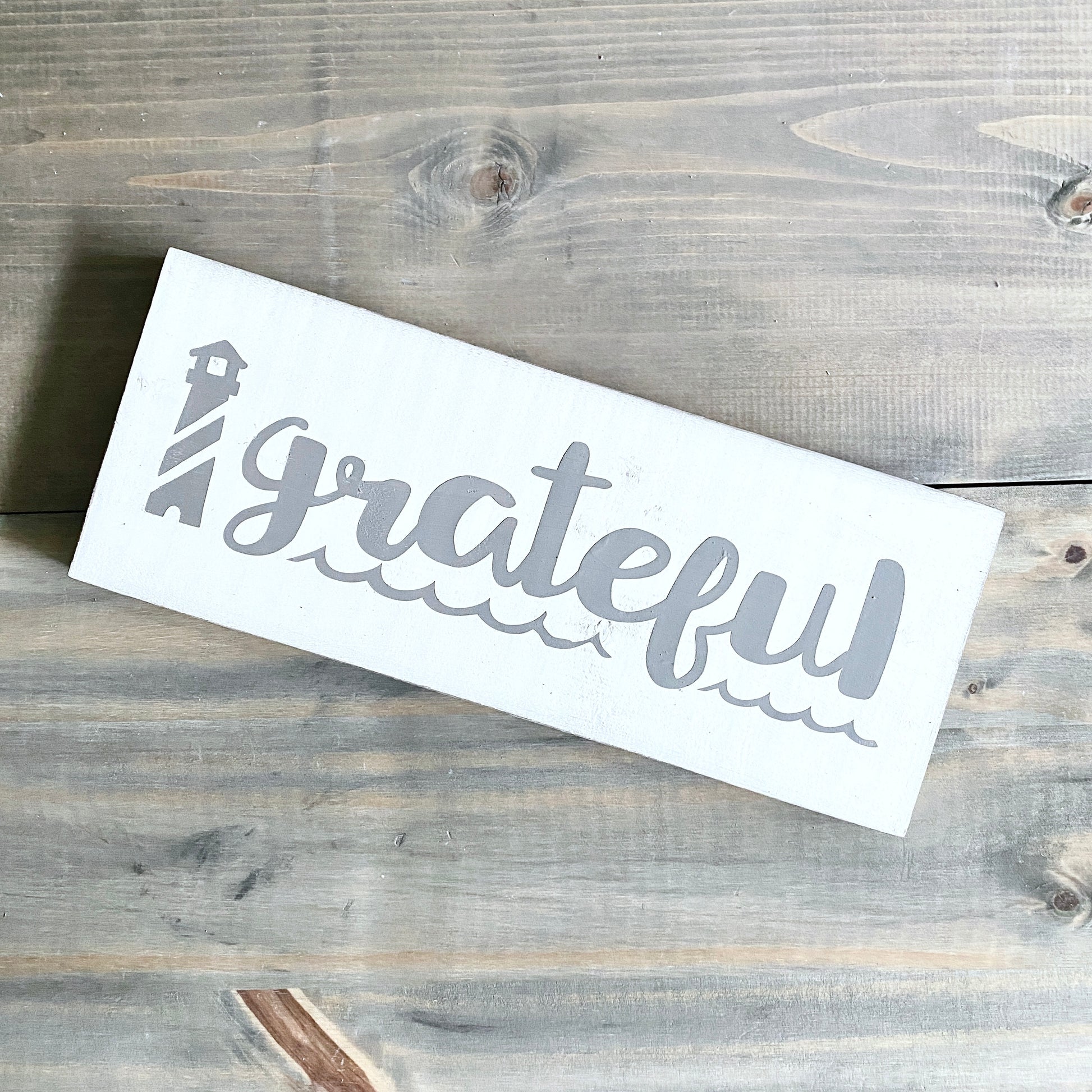 White sign with 'grateful' text on a wooden surface