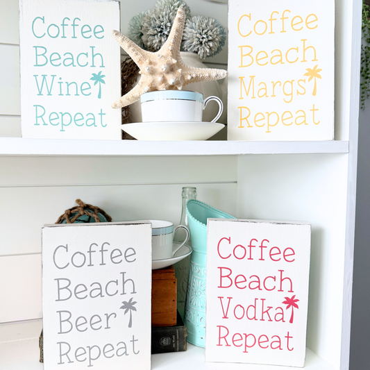 Decorative signs with humorous phrases on a shelf with decorative items. Coffee beach repeat signs