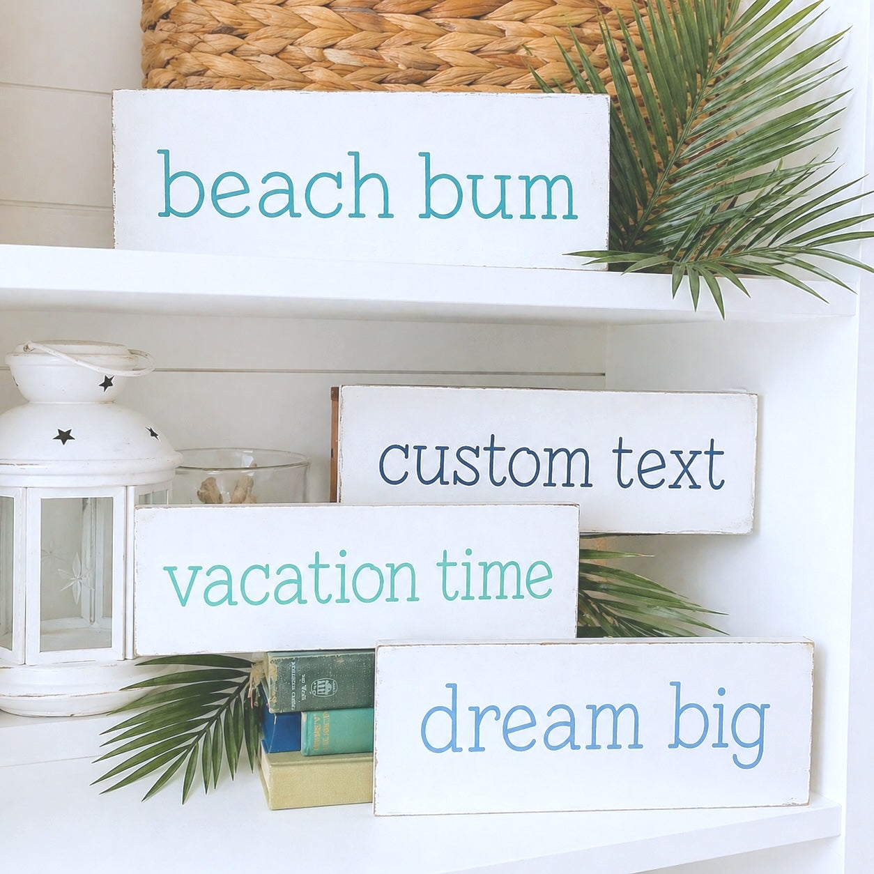 Decorative signs with motivational phrases on a shelf with plants and lanterns.